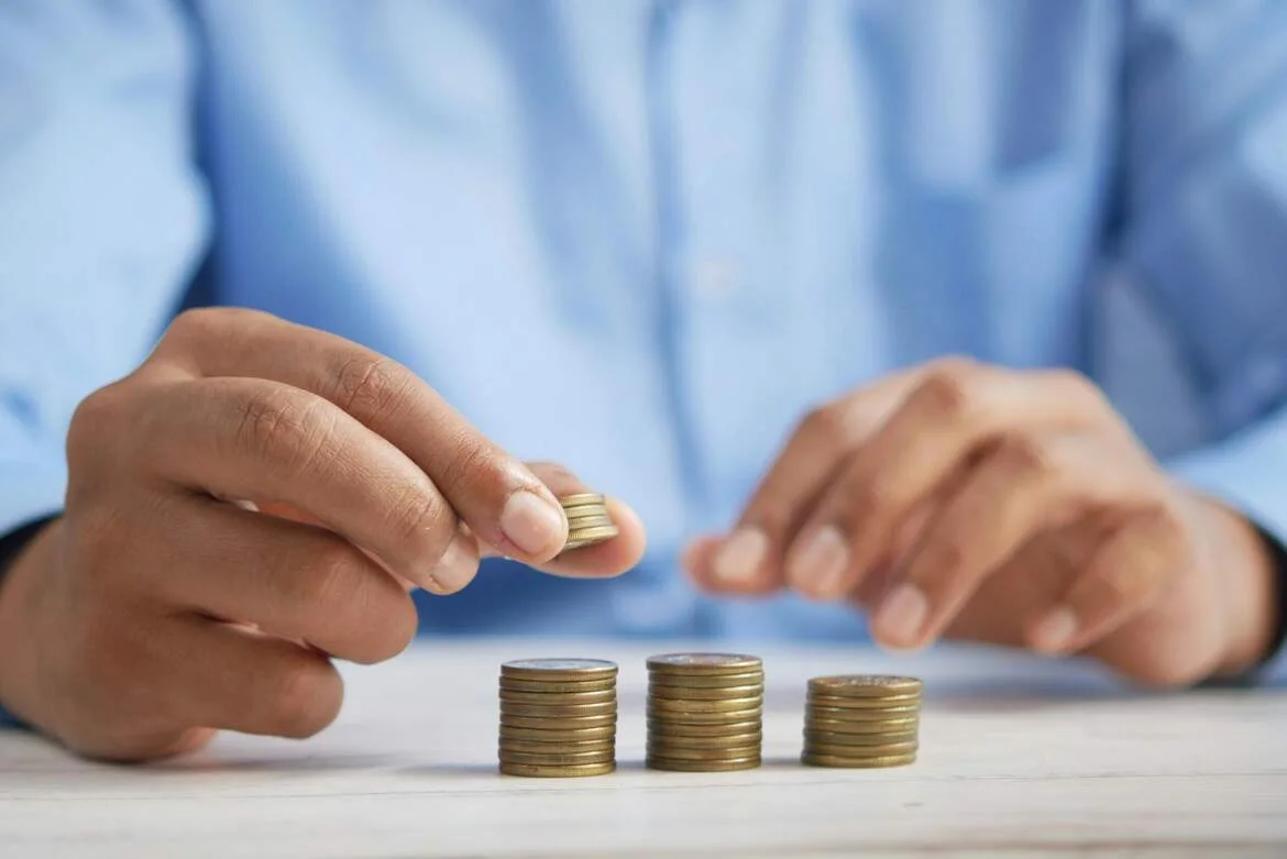 Hands arranging coins while planning a budget